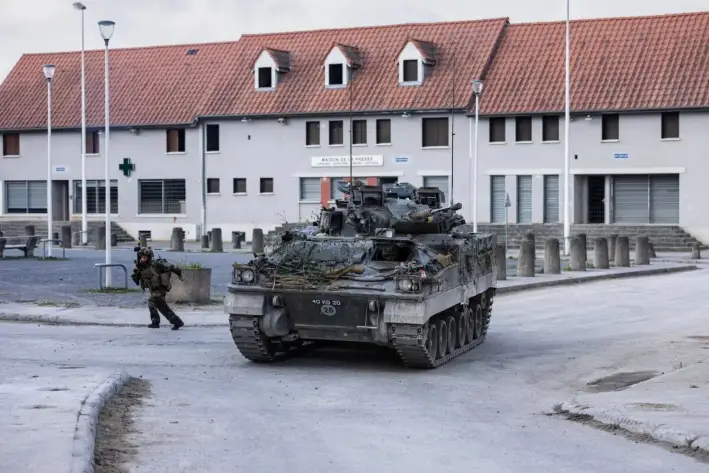 Un soldado se refugia junto a un vehículo blindado británico como parte de un ejercicio de combate urbano durante unas maniobras militares conjuntas entre los ejércitos francés y británico en el campamento de Sissonne, cerca de Reims, Francia, el 22 de abril de 2025. (Sameer Al-Doumy/AFP/Getty Images)
