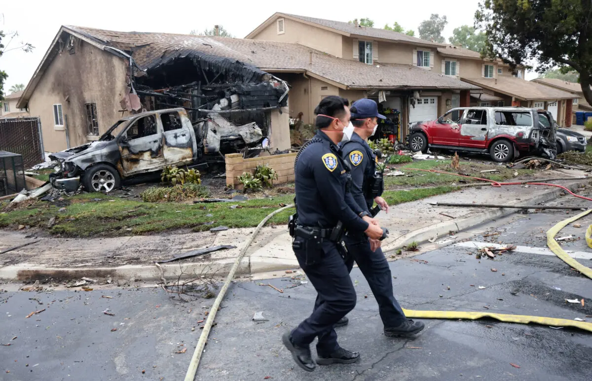 Oficiales de policía registran el lugar donde se estrelló una avioneta en una calle residencial de San Diego, California, el 22 de mayo de 2025. (Foto de Sandy Huffaker/AFP vía Getty Images).