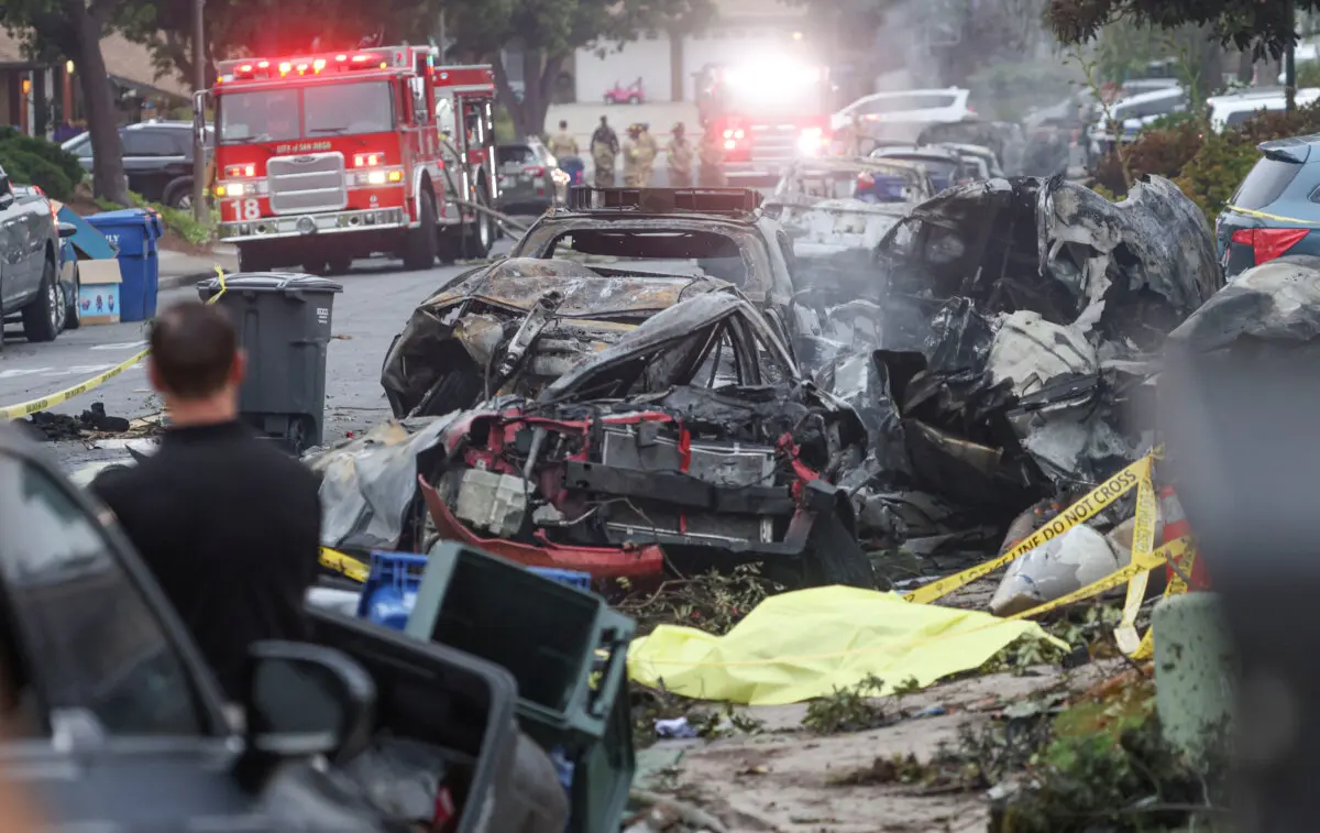Los investigadores examinan el lugar donde se estrelló una avioneta en una calle residencial de San Diego, California, el 22 de mayo de 2025. (Sandy Huffaker/AFP a través de Getty Images).