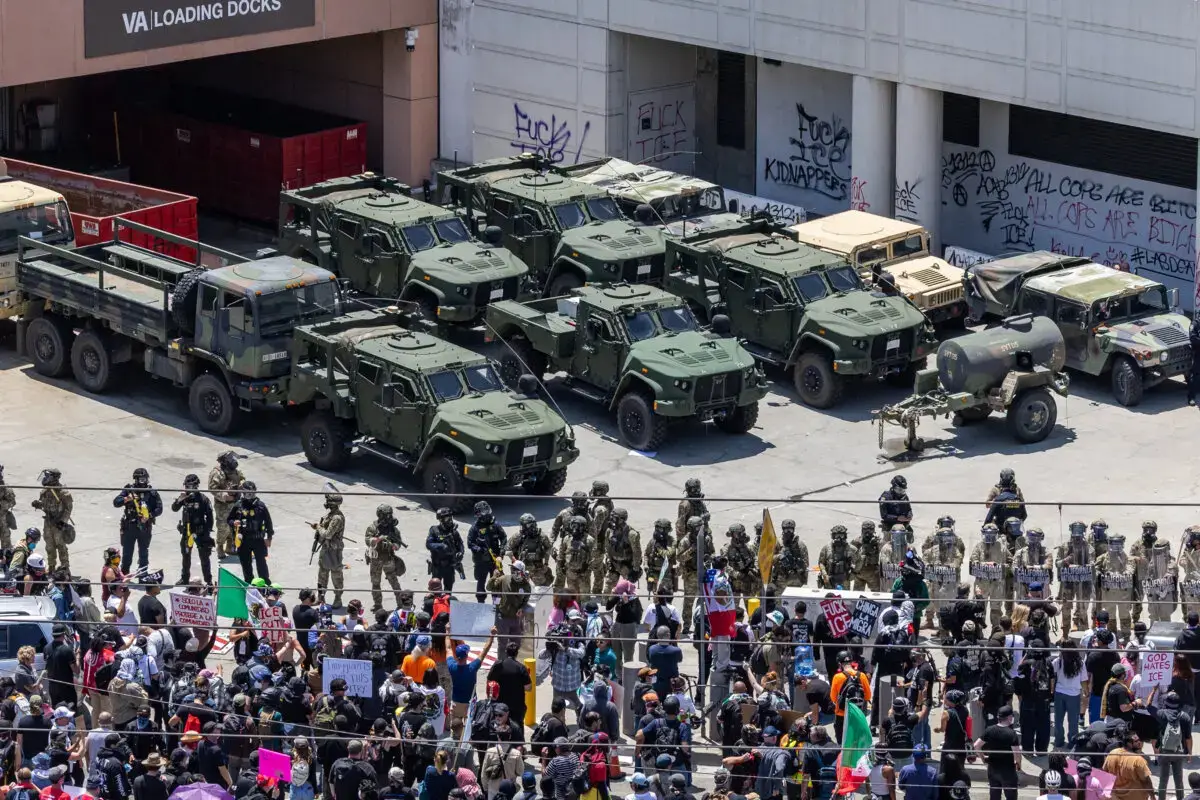 Manifestantes se enfrentan a agentes federales y miembros de la Guardia Nacional de California en Los Ángeles el 8 de junio de 2025. (John Fredricks/The Epoch Times)