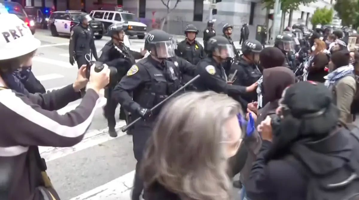Manifestantes se enfrentan a la policía en San Francisco el 8 de junio de 2025, en una imagen tomada de un vídeo. (AP/Captura de pantalla vía The Epoch Times)