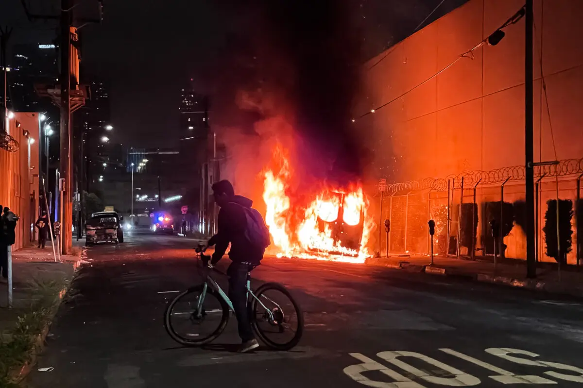 Un coche arde en el centro de Los Ángeles el 8 de junio de 2025. (Melina Chan/The Epoch Times)