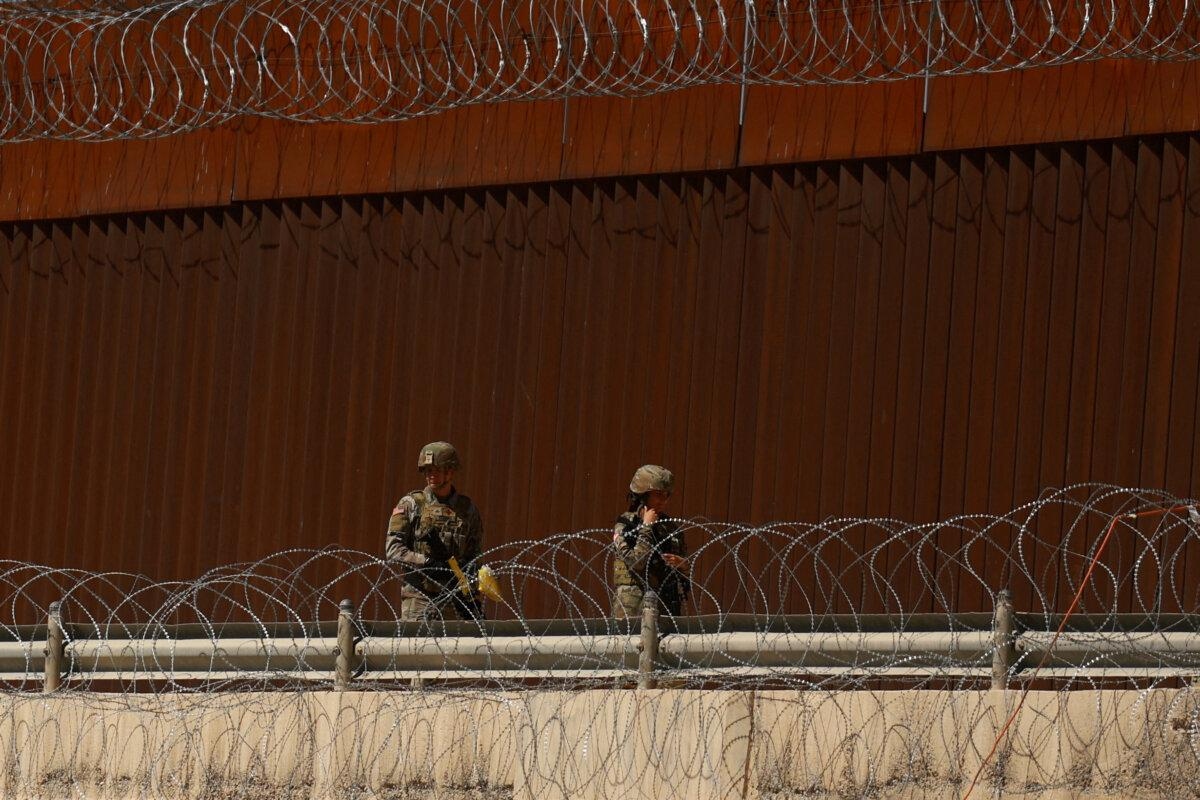 Soldados de la Guardia Nacional de Texas caminan cerca del muro fronterizo entre Estados Unidos y México, visto desde Ciudad Juárez, México, el 11 de marzo de 2025. (José Luis González/Reuters)
