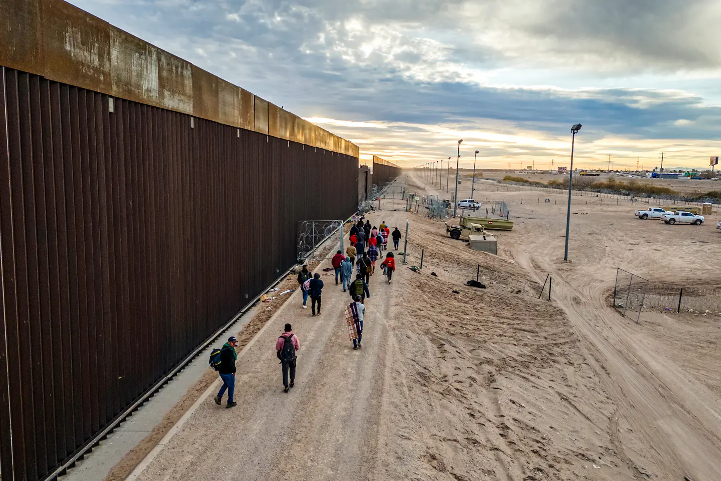 Inmigrantes ilegales caminan a lo largo del muro fronterizo entre Estados Unidos y México tras cruzar el río Grande hacia El Paso, Texas, el 1 de febrero de 2024. El capitán Troy Wilson, miembro de los Texas Rangers, declaró en una audiencia del Senado en mayo que las incursiones de drones a lo largo de la frontera entre Texas y México son un problema creciente. (John Moore/Getty Images).
