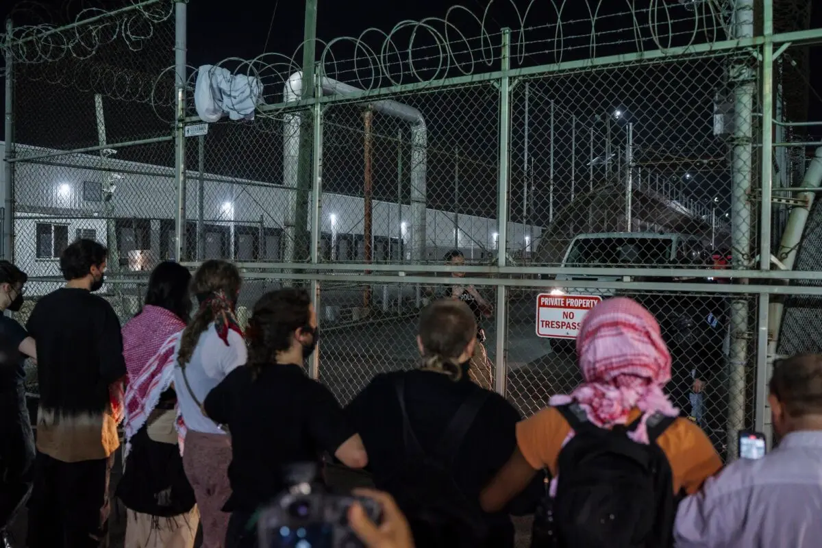 Manifestantes se encadenan a las rejas del centro de detención para impedir la salida de vehículos durante las protestas en Newark, Nueva Jersey, el 12 de junio de 2025. (AP Photo/Olga Fedorova)