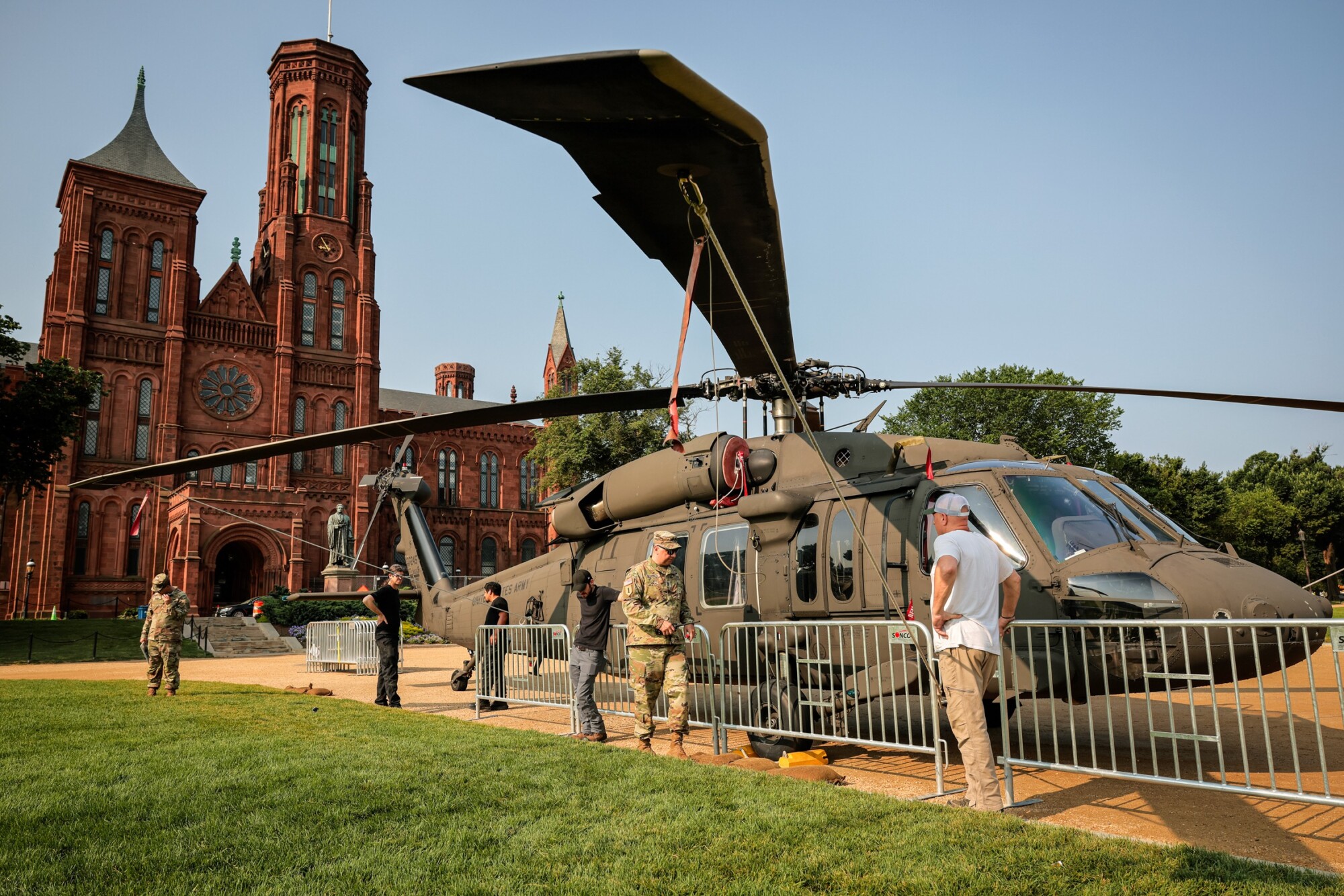 Barricadas rodean un helicóptero Sikorsky UH-60 Black Hawk del Ejército de los Estados Unidos expuesto en el National Mall con motivo de los actos celebrados durante el fin de semana para conmemorar el 250.º aniversario del Ejército, cerca del Castillo Smithsonian, en Washington, el 11 de junio de 2025. (Chip Somodevilla/Getty Images).
