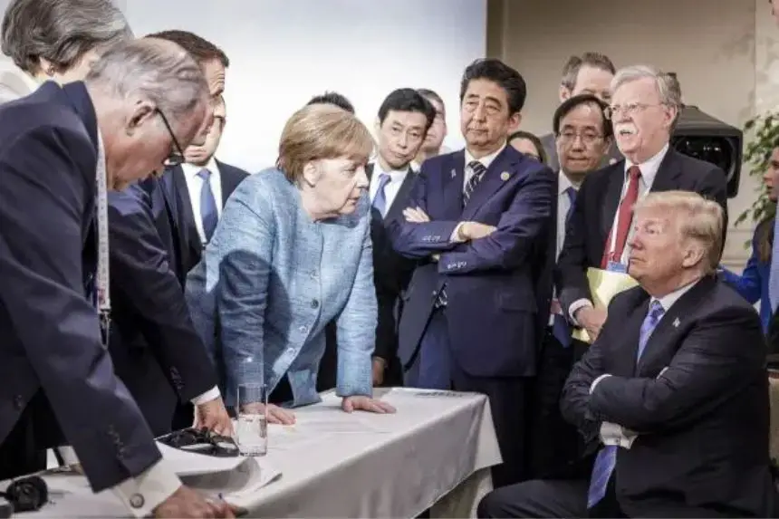 La canciller alemana, Angela Merkel, habla con el presidente Donald Trump ante otros líderes mundiales en Charlevoix, Canadá, durante la cumbre del G7 el 9 de junio de 2018. (Jesco Denzel /Bundesregierung vía Getty Images)