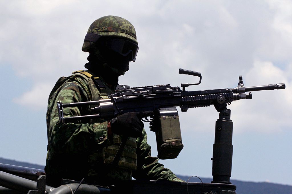 Soldados mexicanos patrullan a lo largo de la carretera Jalisco-Michoacán en Tanhuato, Michoacán, el 23 de mayo de 2015. Al menos 42 personas, incluyendo dos policías, murieron en el tiroteo en el conflictivo estado occidental de Michoacán, en uno de los enfrentamientos más sangrientos de la guerra contra el narcotráfico en el país. (HECTOR GUERRERO/AFP via Getty Images)