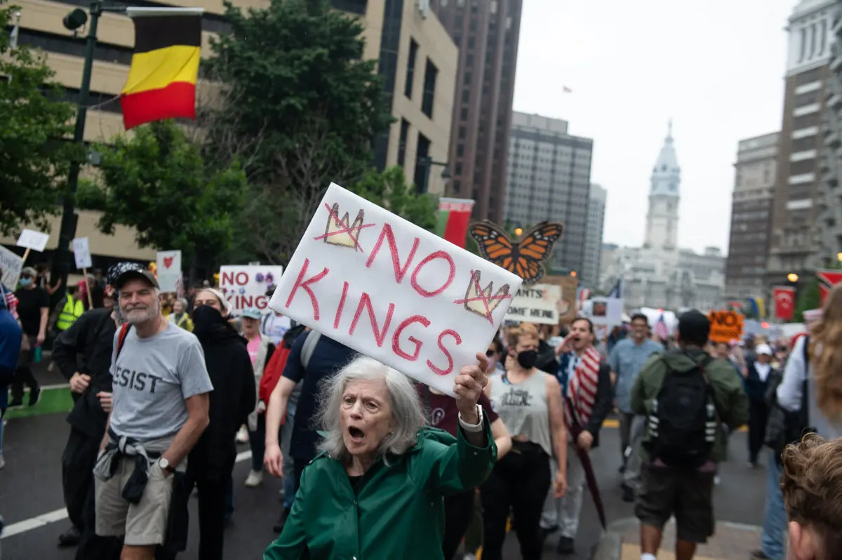 Un manifestante sostiene una pancarta durante una marcha por la Benjamin Franklin Parkway hacia el Museo de Arte de Filadelfia durante una manifestación nacional "No Kings" en Filadelfia, Pensilvania, el 14 de junio de 2025. (Erin Blewett /AFP vía Getty Images)