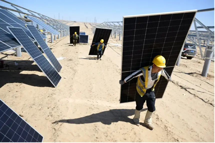 Trabajadores transportan paneles solares para su instalación en el desierto en el proyecto fotovoltaico de un millón de kilovatios Ningguoyun Lingwu en Lingwu, en la región norteña china de Ningxia, el 14 de abril de 2025. (AFP vía Getty Images)