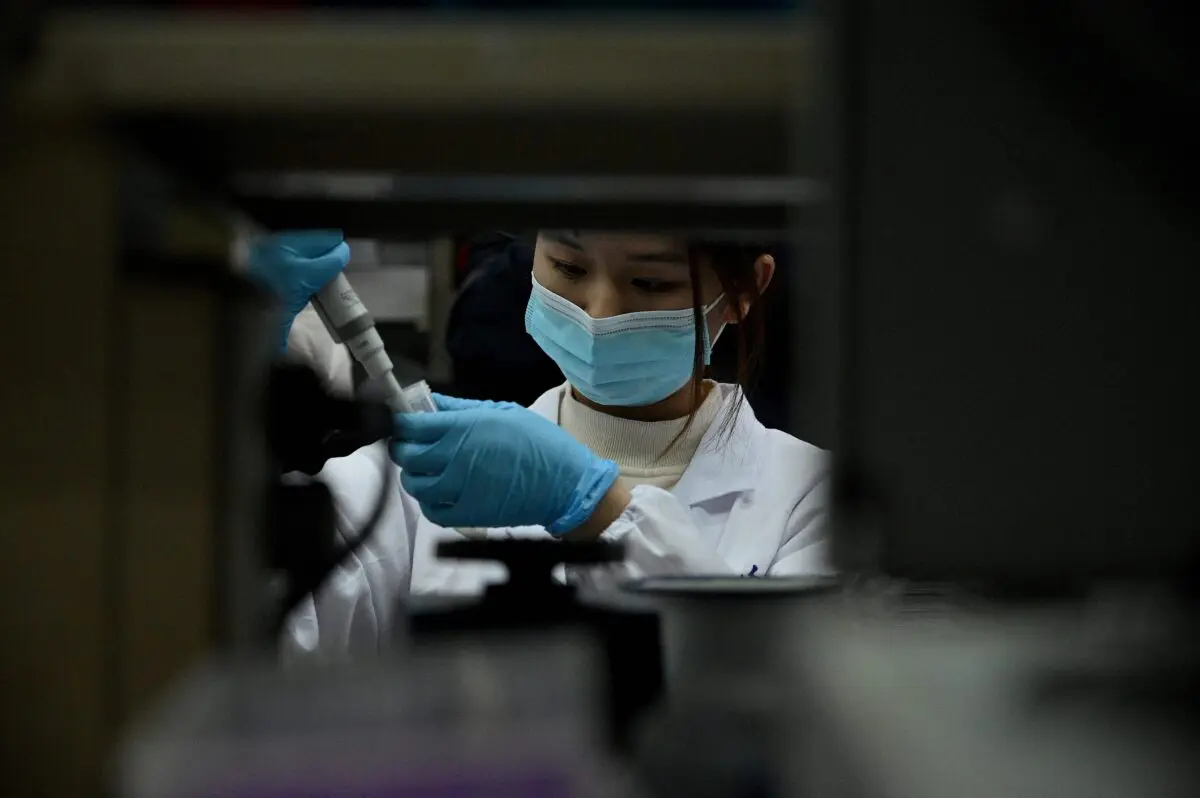 Una técnica de laboratorio trabaja en un laboratorio de la Universidad de Tsinghua en Beijing el 9 de diciembre de 2021. (Noel Celis/AFP a través de Getty Images)
