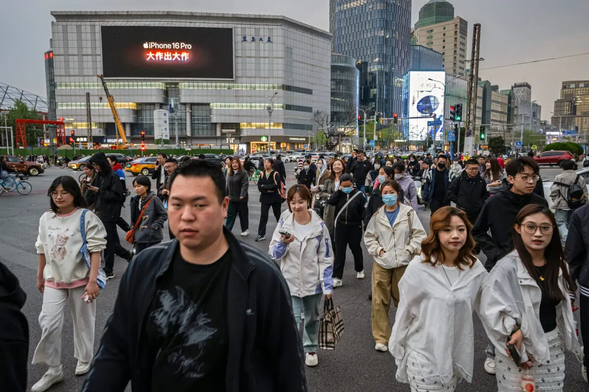 Personas cruzan un semáforo en Beijing el 8 de abril de 2025. (Kevin Frayer/Getty Images)