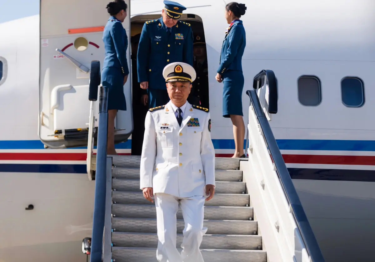 El almirante Miao Hua (C), director del departamento de asuntos políticos de la Comisión Militar Central de China, desembarca de su avión tras llegar al aeropuerto internacional de Pyongyang el 14 de octubre de 2019. (Kim Won Jin/AFP vía Getty Images).