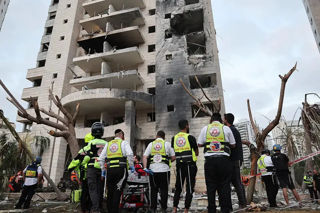 Se ven equipos de emergencia junto a un edificio dañado tras un ataque con misiles iraníes en la ciudad israelí de Petah Tikva, al este de Tel Aviv, el 16 de junio de 2025. (Jack Guez/AFP a través de Getty Images)
