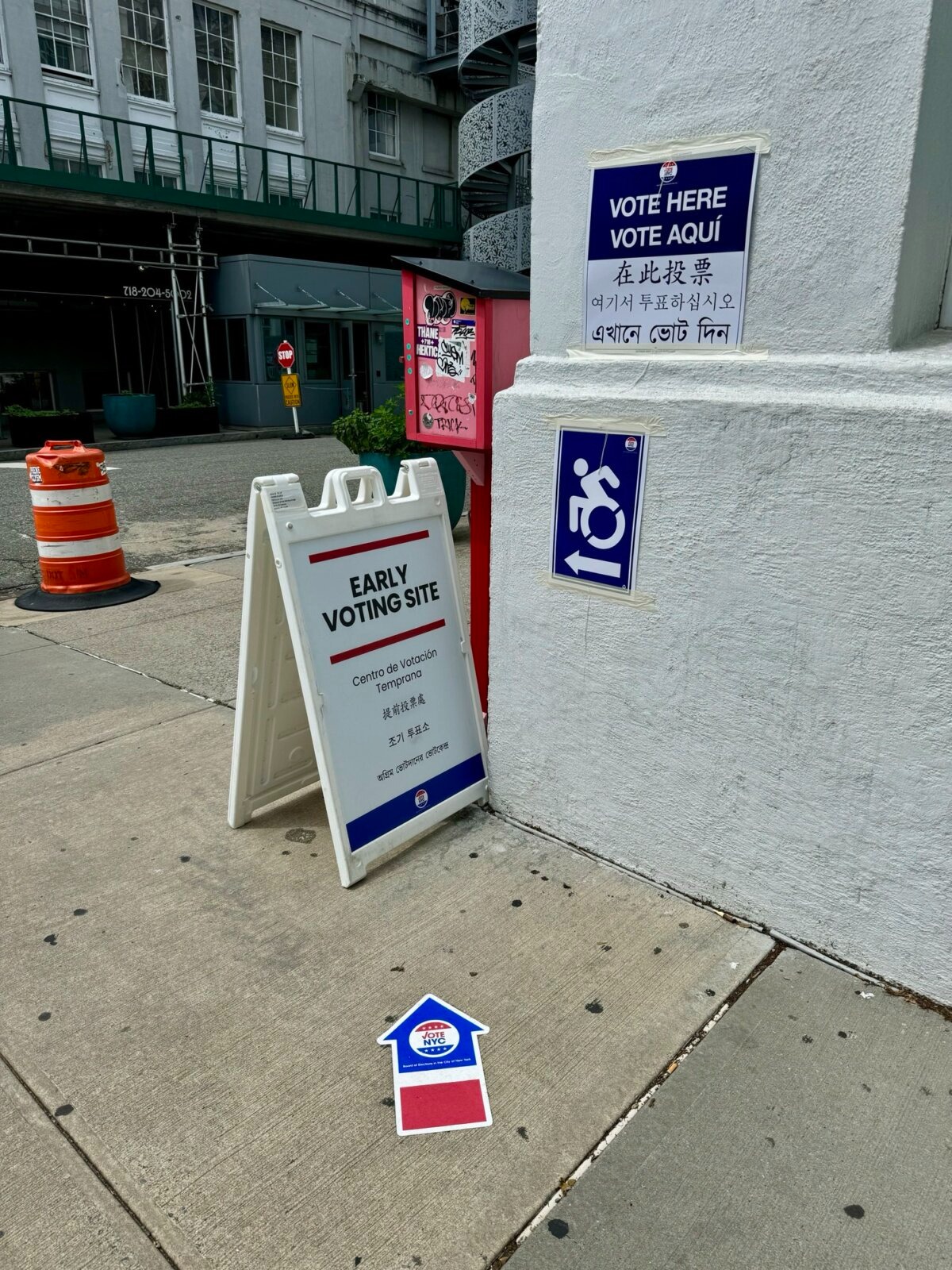 Se muestran carteles en varios idiomas fuera de un colegio electoral en Astoria, Queens, Nueva York, durante las primarias. (Arjun Singh/The Epoch Times).