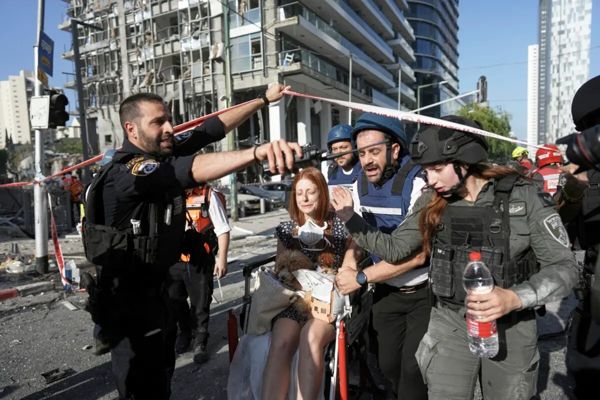 Una mujer es evacuada del lugar donde ha impactado un misil iraní en Ramat Gan, Israel, el 19 de junio de 2025. (Oded Balilty/AP)