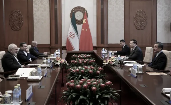 El ministro de Asuntos Exteriores de China, Wang Yi (dcha.), conversa con el ministro de Asuntos Exteriores de Irán, Mohammad Javad Zarif (izq.), durante su reunión en la Casa de Huéspedes de Estado Diaoyutai en Beijing el 31 de diciembre de 2019. (Noel Celis / POOL/AFP vía Getty Images)