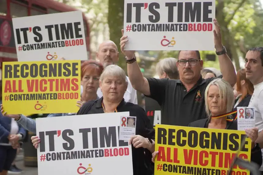 Activistas, entre ellos muchos afectados personalmente, protestan frente a la Comisión de Investigación sobre la Sangre Contaminada en Londres el 26 de julio de 2023. (Victoria Jones/PA Wire)
