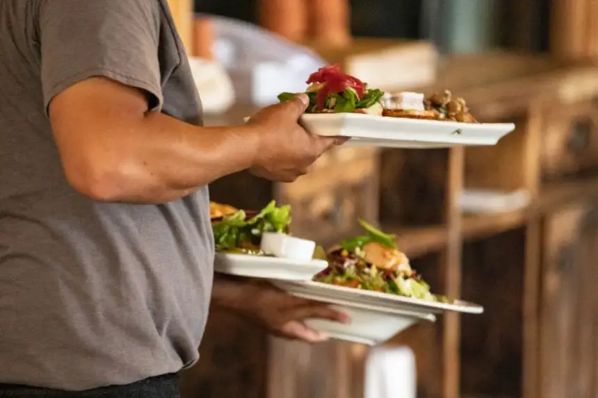 Un camarero lleva comida en el restaurante The Farmhouse de Newport Beach, California, el 9 de septiembre de 2020. (John Fredricks/The Epoch Times)