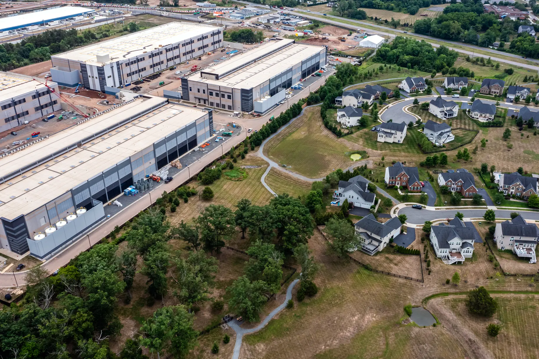 Un centro de datos de Amazon Web Services visto cerca de viviendas unifamiliares en Stone Ridge, Virginia, el 17 de julio de 2024. Según un informe reciente, el norte de Virginia es el mayor mercado de centros de datos del mundo, pero se enfrenta a retos cada vez mayores en cuanto a la disponibilidad de terrenos y energía. (Nathan Howard/Getty Images).