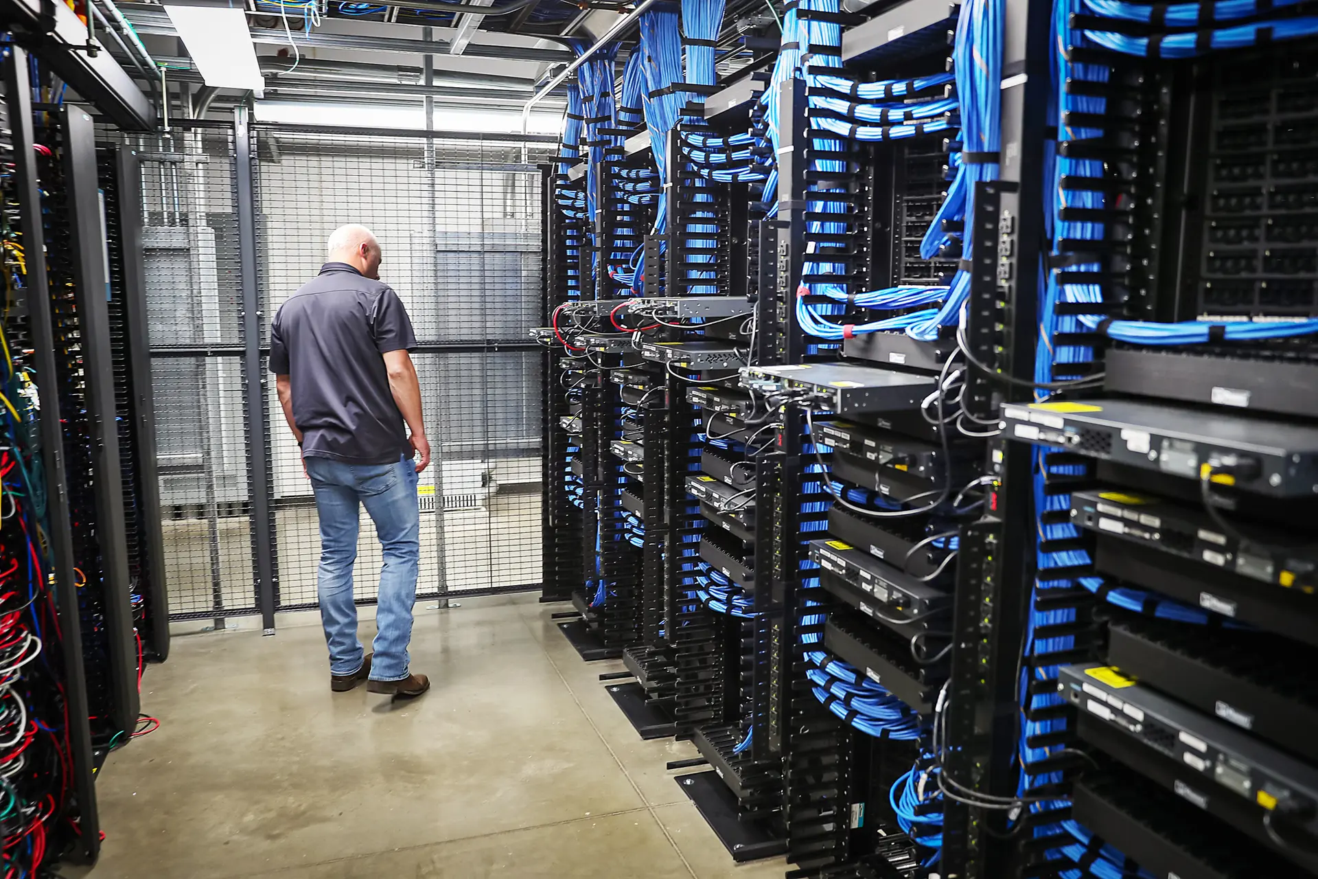 Un trabajador camina entre estantes y conmutadores de red en el centro de datos LightEdge Solutions en Altoona, Iowa, el 15 de octubre de 2019. (Joe Raedle/Getty Images).