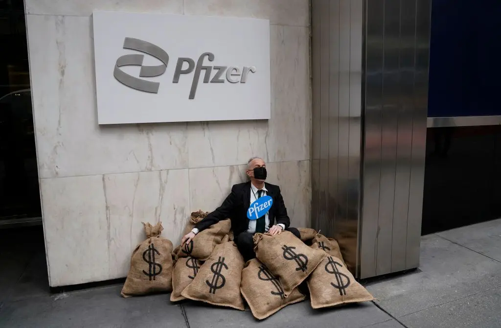 El Centro para la Democracia Popular organizó una simulación teatral en la calle de un atraco frente a la sede de Pfizer en Nueva York el 25 de abril de 2022 para reclamar un acceso equitativo a las vacunas y los tratamientos contra el coronavirus (COVID-19) en todo el mundo. (Timothy A. Clary/AFP a través de Getty Images).