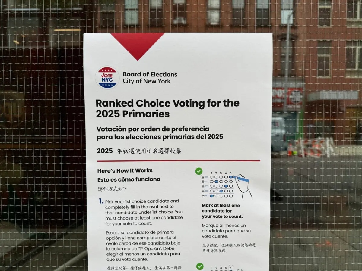 Un cartel de la Junta Electoral de la ciudad de Nueva York fuera de un colegio electoral explica el proceso de "voto por orden de preferencia" a los votantes el 16 de junio de 2025. (Arjun Singh/The Epoch Times)
