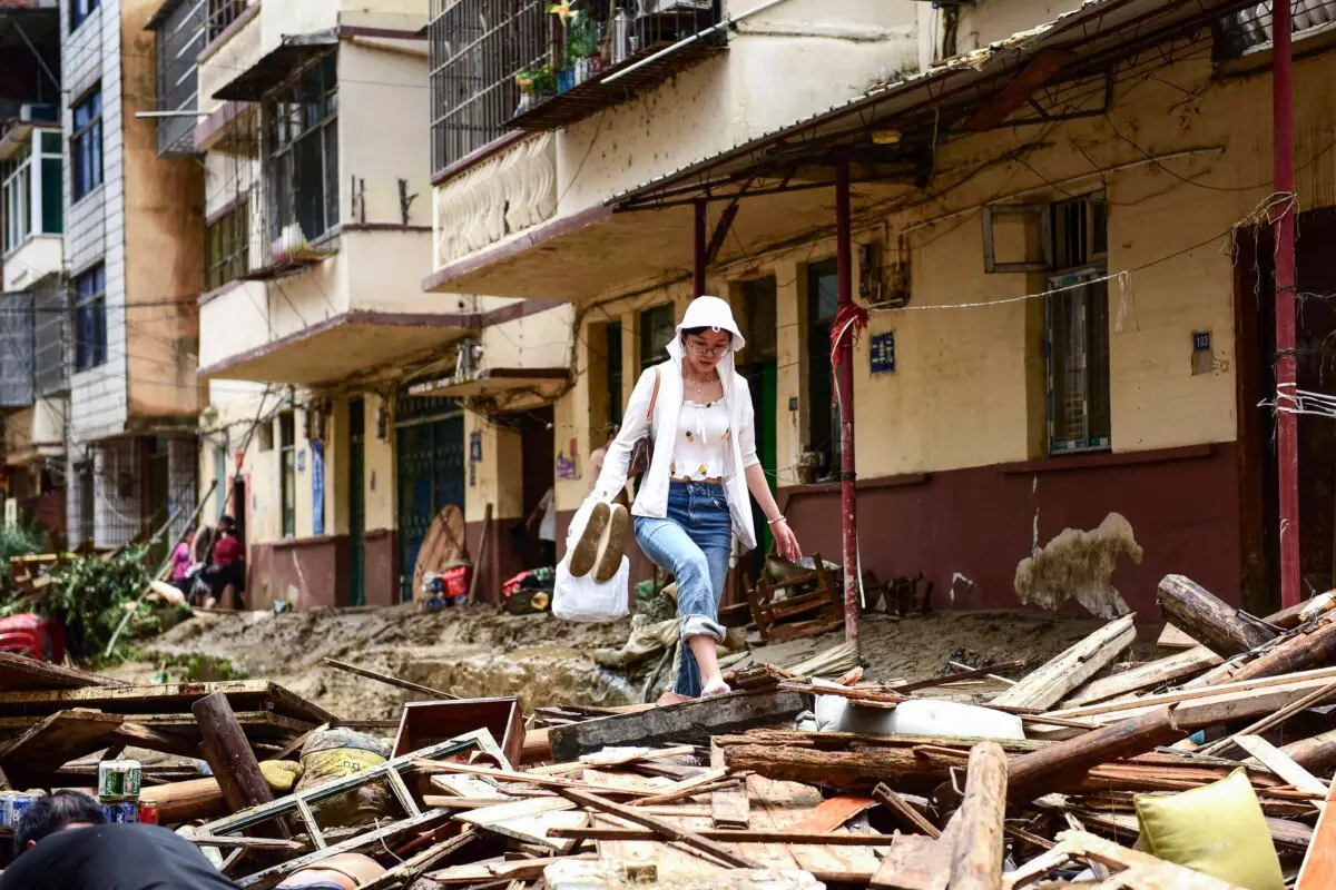 Una mujer camina entre los escombros en una zona afectada por las inundaciones en Congjiang, en el suroeste de la provincia de Guizhou, China, el 25 de junio de 2025. (STR/AFP vía Getty Images)