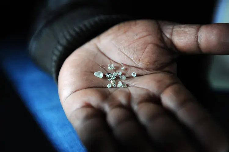 <em>Un minero muestra diamantes extraídos de una mina abandonada en Komaggas, Sudáfrica, en junio de 2012. Alexander Joe/AFP/Getty Images</em>