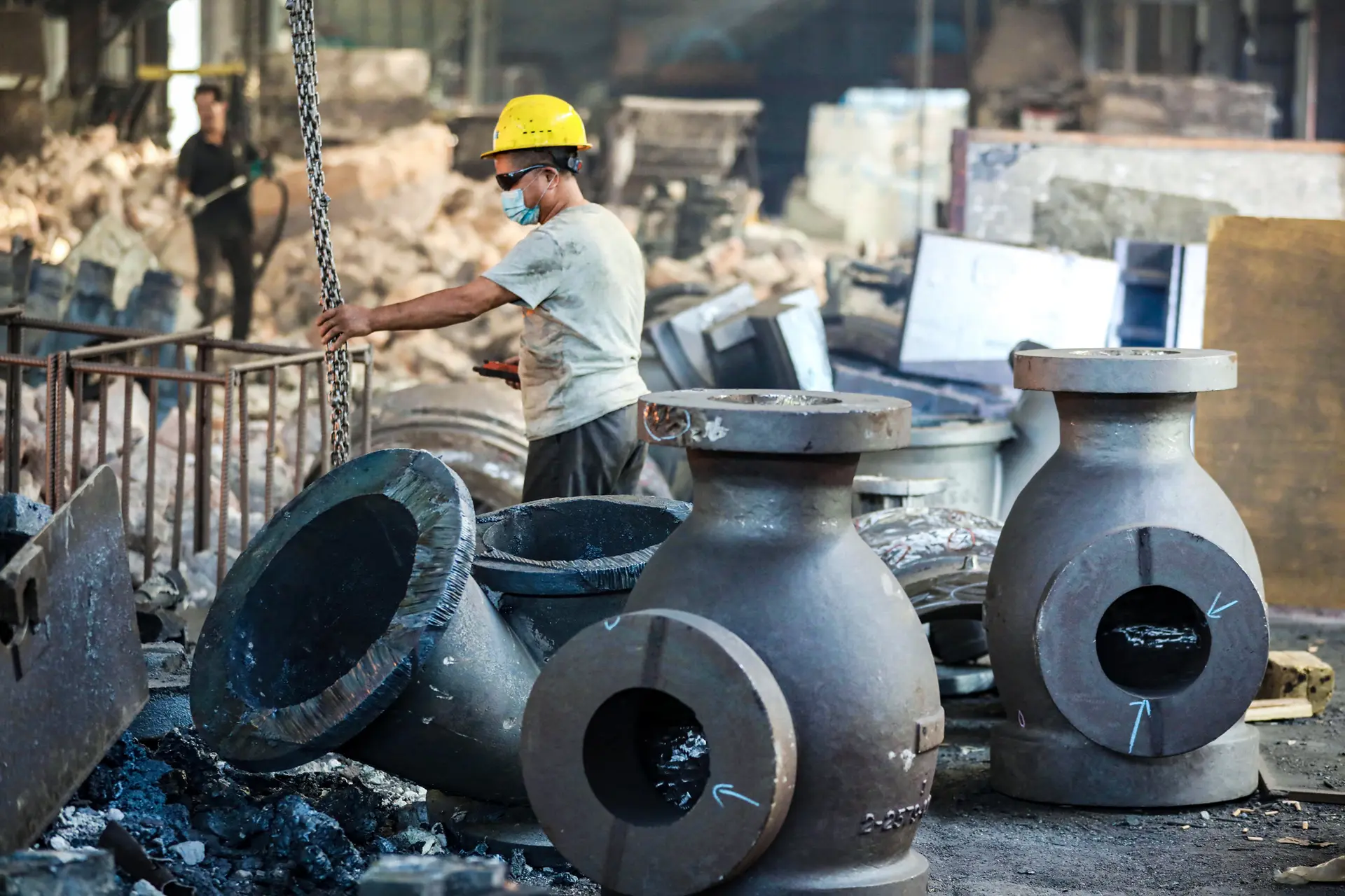 Un trabajador mueve piezas de maquinaria de acero en una empresa manufacturera en Hangzhou, provincia de Zhejiang, China, el 16 de junio de 2025. La producción industrial de China aumentó menos de lo esperado en mayo, en medio de la continua incertidumbre derivada de la guerra comercial con Estados Unidos. (STR/AFP a través de Getty Images)