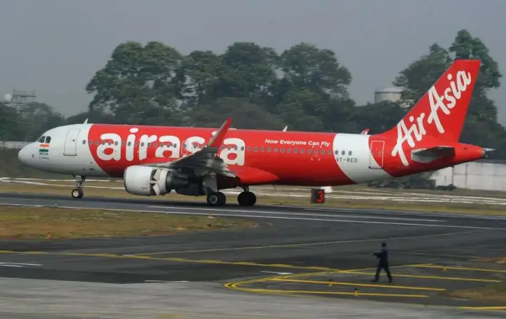 Un empleado del aeropuerto indio camina junto a un avión de AirAsia tras aterrizar en su vuelo inaugural desde Nueva Delhi al aeropuerto de Bagdogra, a unos 20 km de Siliguri, el 19 de febrero de 2017. (Diptendu Dutta/AFP/Getty Images)