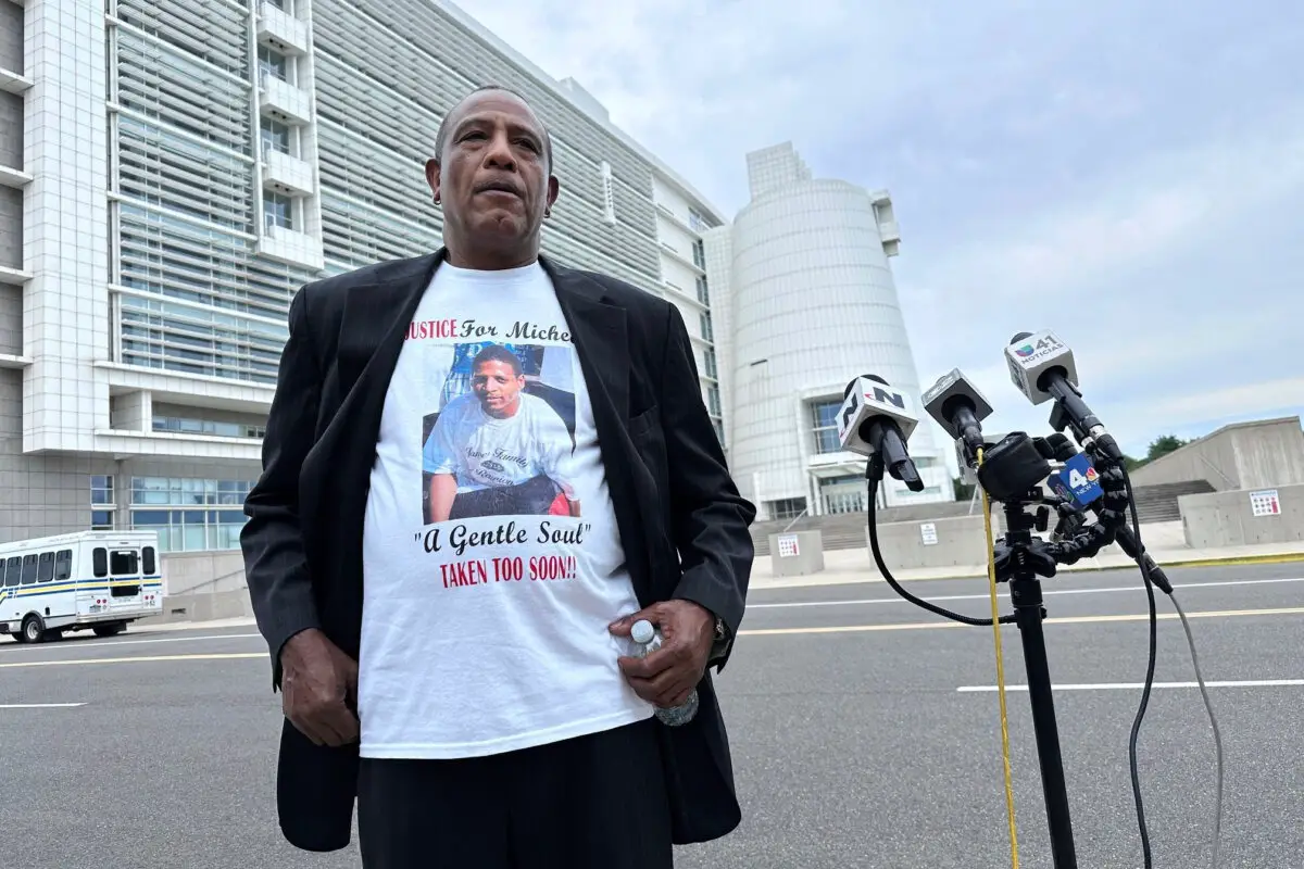 George Johnson frente a la corte federal de Central Islip, Nueva York, el 2 de julio de 2025, con una camiseta con la imagen de su hijo, Michael Johnson, asesinado por miembros de la banda MS-13 en 2016. (Philip Marcelo/AP Photo).