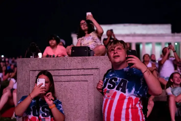 Visitantes contemplan los fuegos artificiales del Día de la Independencia cerca del Monumento a Lincoln en el National Mall de Washington, el 4 de julio de 2021. (Alex Edelman/AFP a través de Getty Images)