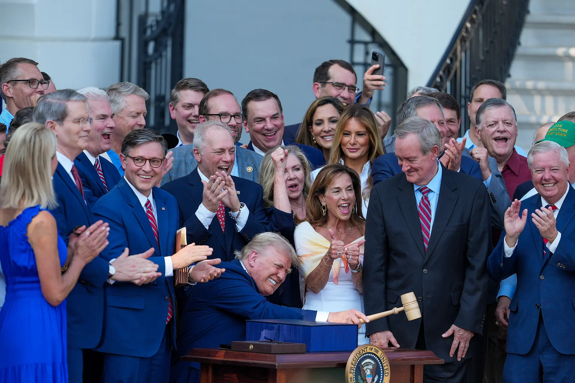 El presidente Donald Trump, acompañado por legisladores republicanos, promulga la One Big Beautiful Bill durante un picnic familiar militar por el Día de la Independencia en el jardín sur de la Casa Blanca, en Washington el 4 de julio de 2025. (Eric Lee/Getty Images)