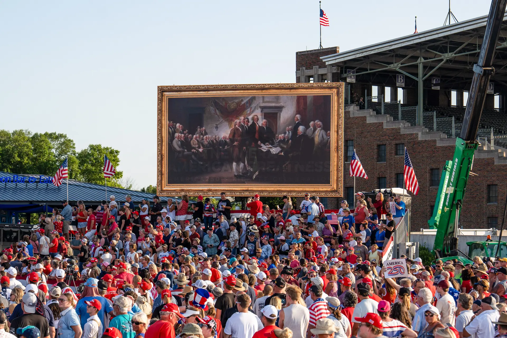 Personas reunidas escuchan el discurso del presidente Donald Trump en el recinto ferial estatal de Iowa durante el inicio de una de las preparaciones para el 250 aniversario de la firma de la Declaración de Independencia, en Des Moines, Iowa, el 3 de julio de 2025. (Madalina Kilroy/The Epoch Times)