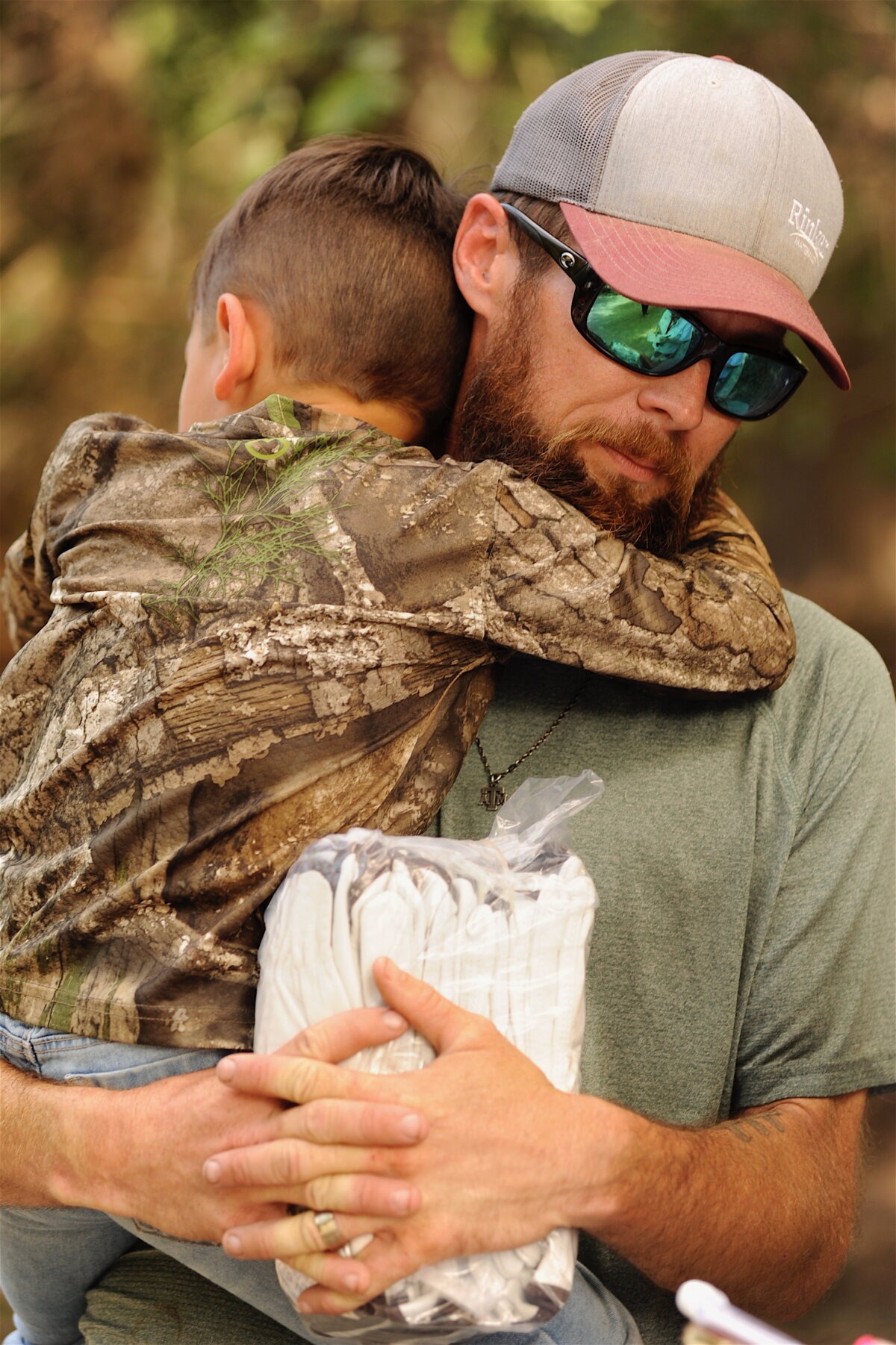 Zachary Clark sostiene a su hijo de 5 años mientras describe la catastrófica inundación a lo largo del río Guadalupe cerca de Comfort, Texas, el 7 de julio de 2025. (Neil Hernandez para The Epoch Times).