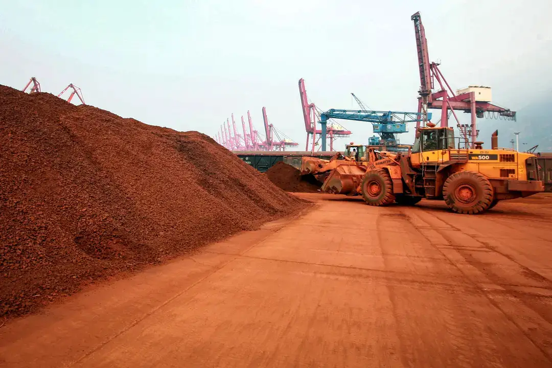 Un hombre conduce una pala cargadora para trasladar tierra que contiene minerales de tierras raras para su exportación a Japón en un puerto de Lianyungang, provincia de Jiangsu, China, el 5 de septiembre de 2010. China tiene el monopolio casi absoluto de la industria de las tierras raras, desde la extracción y el refinado hasta la fabricación de imanes. (STR/AFP a través de Getty Images)