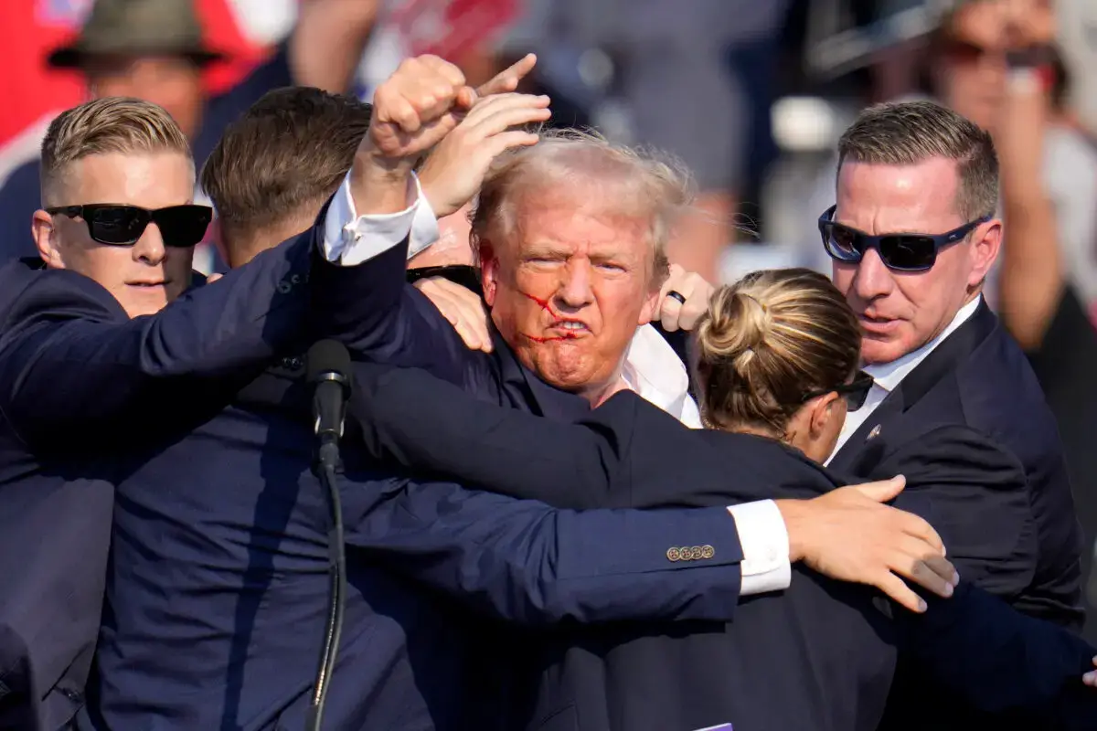 El candidato presidencial republicano y expresidente Donald Trump levanta el puño mientras le ayudan a bajar del escenario en un acto de campaña en Butler, Pensilvania, el 13 de julio de 2024. (Gene J. Puskar/AP Photo)