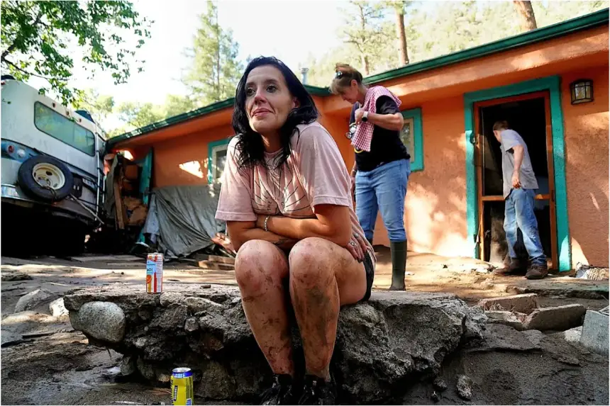 Kalyn Sheffield se sienta afuera de la casa de su madre mientras su madre, Stephanie Sheffield, y su hijo adolescente, Matthew, limpian otra propiedad arruinada por las inundaciones monzónicas en Ruidoso, Nuevo México, el 8 de julio. (Allan Stein/The Epoch Times)