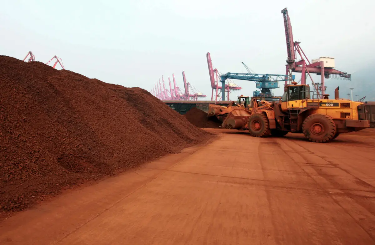 Un hombre que conduce una pala cargadora traslada tierra que contiene minerales de tierras raras en un puerto de Lianyungang, provincia china de Jiangsu, el 5 de septiembre de 2010. (AFP vía Getty Images)