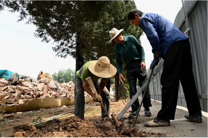 Trabajadores migrantes plantan árboles en un parque en el barrio de clase media de Shangdi, en Beijing, el 1 de julio de 2022. (Noel Celis/AFP vía Getty Images)