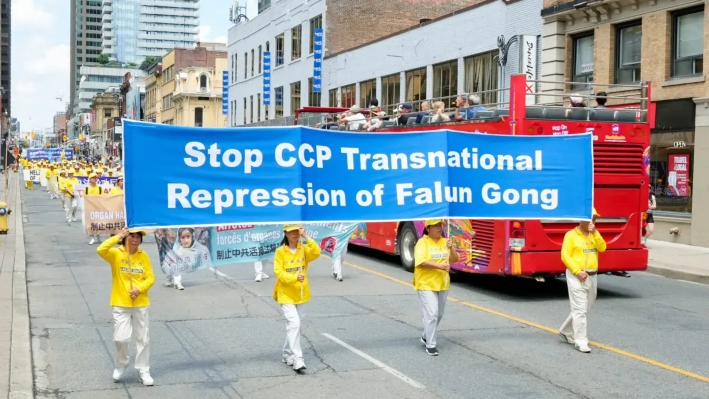 Practicantes de Falun Gong desfilan por el centro de Toronto el 13 de julio de 2025 para conmemorar el 26.° aniversario de la persecución contra Falun Gong por parte del Partido Comunista Chino. (Vincent Du/The Epoch Times)