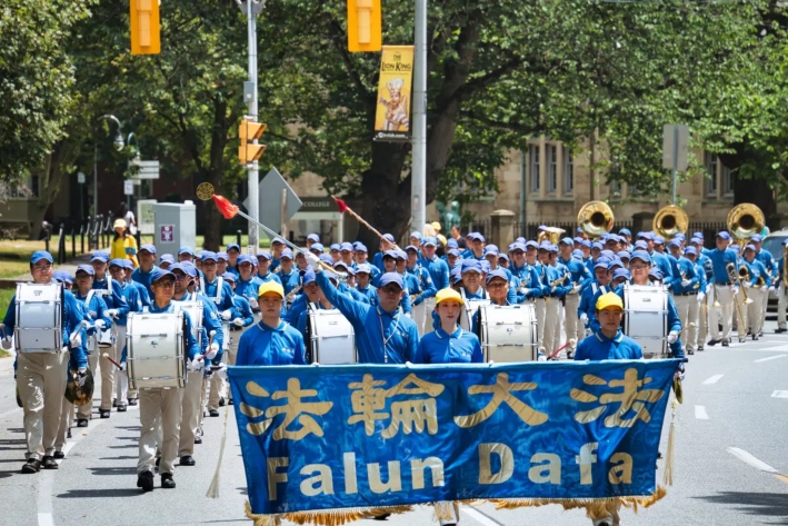 La banda de música Tian Guo participa en un desfile por el centro de Toronto para conmemorar el 26.° aniversario de la persecución contra Falun Gong en China, el 13 de julio de 2025. (Jerry Zhang/The Epoch Times)