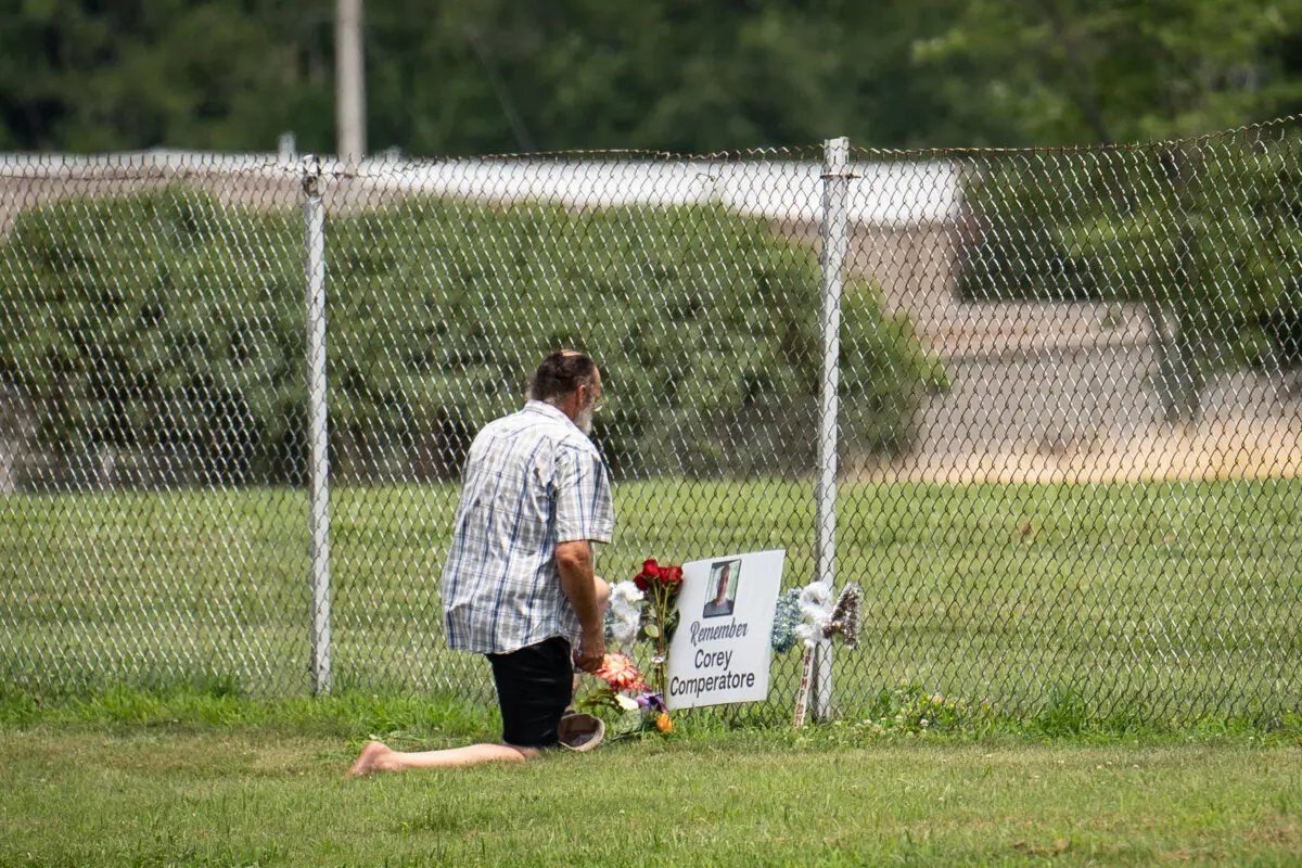 Shawn Morin deposita flores en un memorial en memoria de Corey Comperatore en el condado de Butler, Pensilvania, el 13 de julio de 2025. (Samira Bouaou/The Epoch Times)