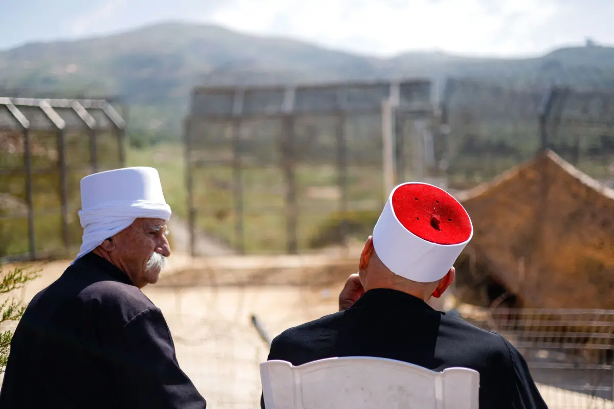 Clérigos drusos esperan la llegada de dignatarios drusos procedentes de Siria a través de una barrera custodiada por soldados israelíes cerca de la aldea de Majdal Shams, en los Altos del Golán, anexionados por Israel, el 25 de abril de 2025. (Jalaa Marey/AFP a través de Getty images).