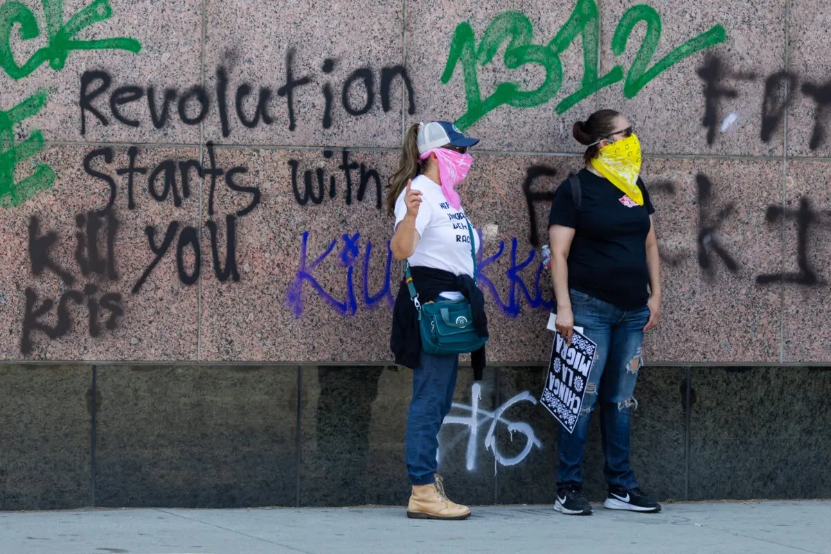 Manifestantes frente a pintadas contra el ICE en un edificio federal en Los Ángeles el 8 de junio de 2025. (John Fredricks/The Epoch Times)