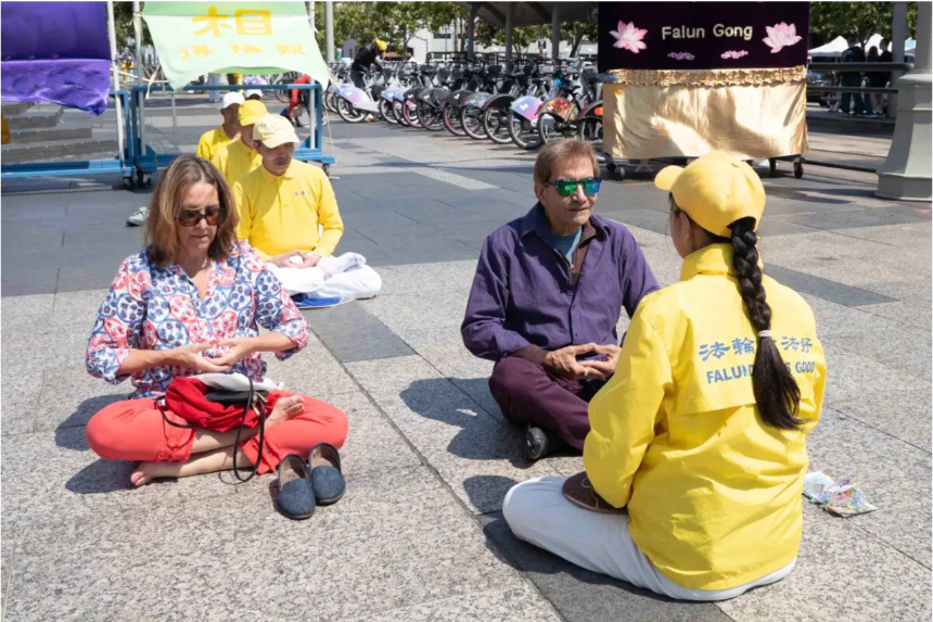 Sam (2o-d) aprende el quinto ejercicio de Falun Gong en Harry Bridges Plaza, en San Francisco, el 12 de julio de 2025. (Gary Wang/The Epoch Times)