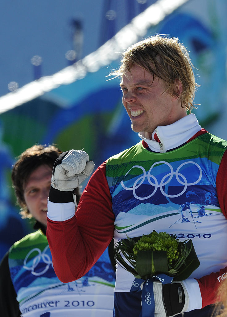 El medallista de bronce noruego Audun Groenvold celebra en el podio durante la ceremonia de entrega de flores de las eliminatorias masculinas de esquí cross libre en Cypress Mountain, al norte de Vancouver, durante los Juegos Olímpicos de Invierno de Vancouver, el 21 de febrero de 2010. (ADRIAN DENNIS/AFP a través de Getty Images)