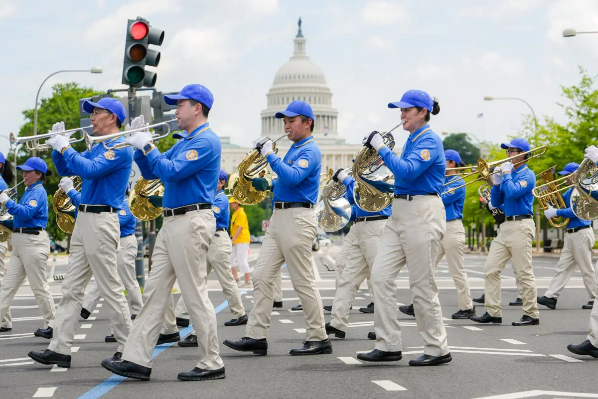 Practicantes de Falun Dafa participan en una marcha para pedir el fin de los 26 años de persecución del Falun Gong por parte del Partido Comunista Chino en China, en Washington, el 17 de julio de 2025. )Madalina Kilroy/The Epoch Times)
