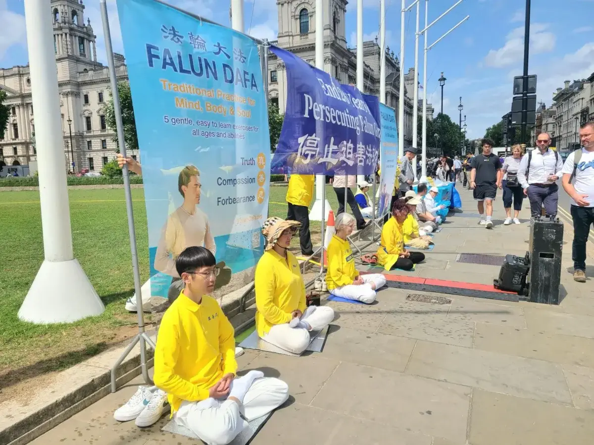 Practicantes de Falun Gong realizan una manifestación pacífica frente al Parlamento del Reino Unido durante un seminario el 15 de julio de 2025. (Yueyang Lee/The Epoch Times).